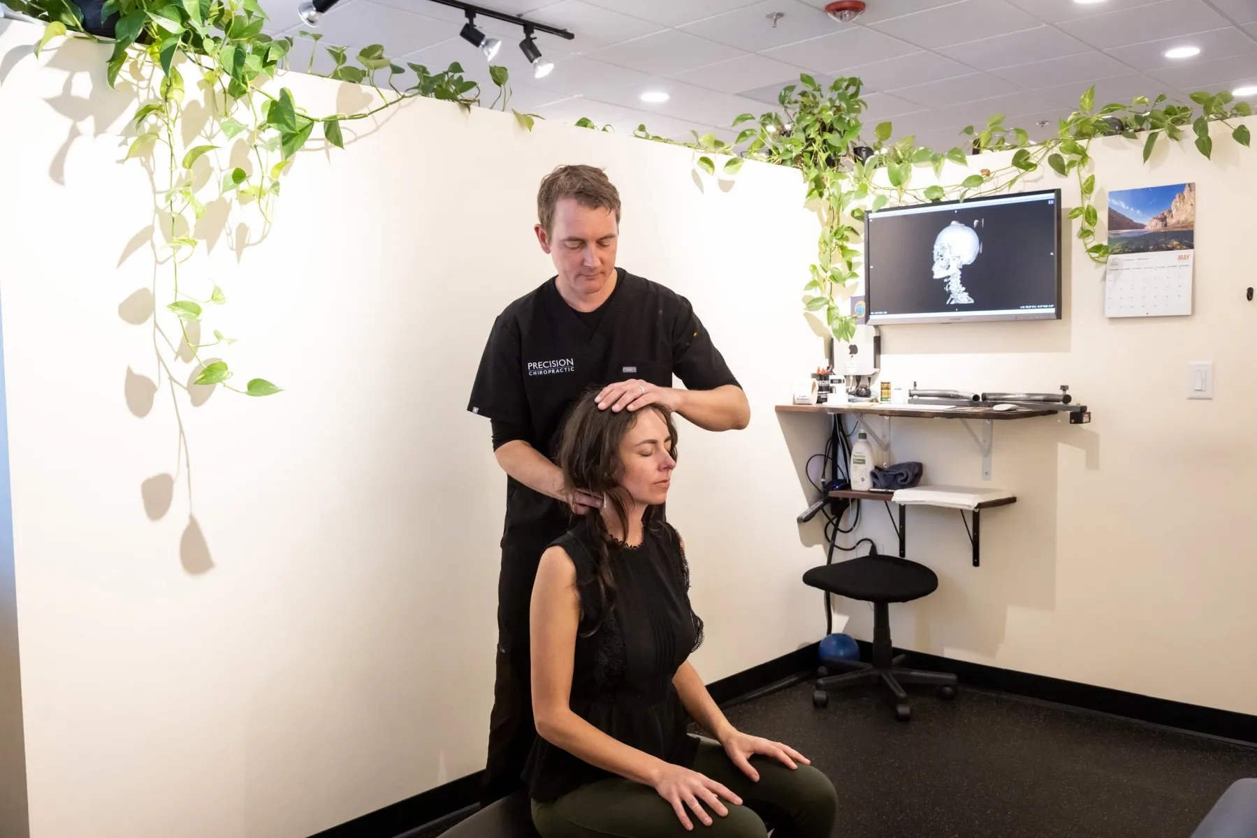 Dr. McCanse performing a seated upper cervical spinal assessment to evaluate structural alignment and nervous system function at Precision Chiropractic in Vermont.