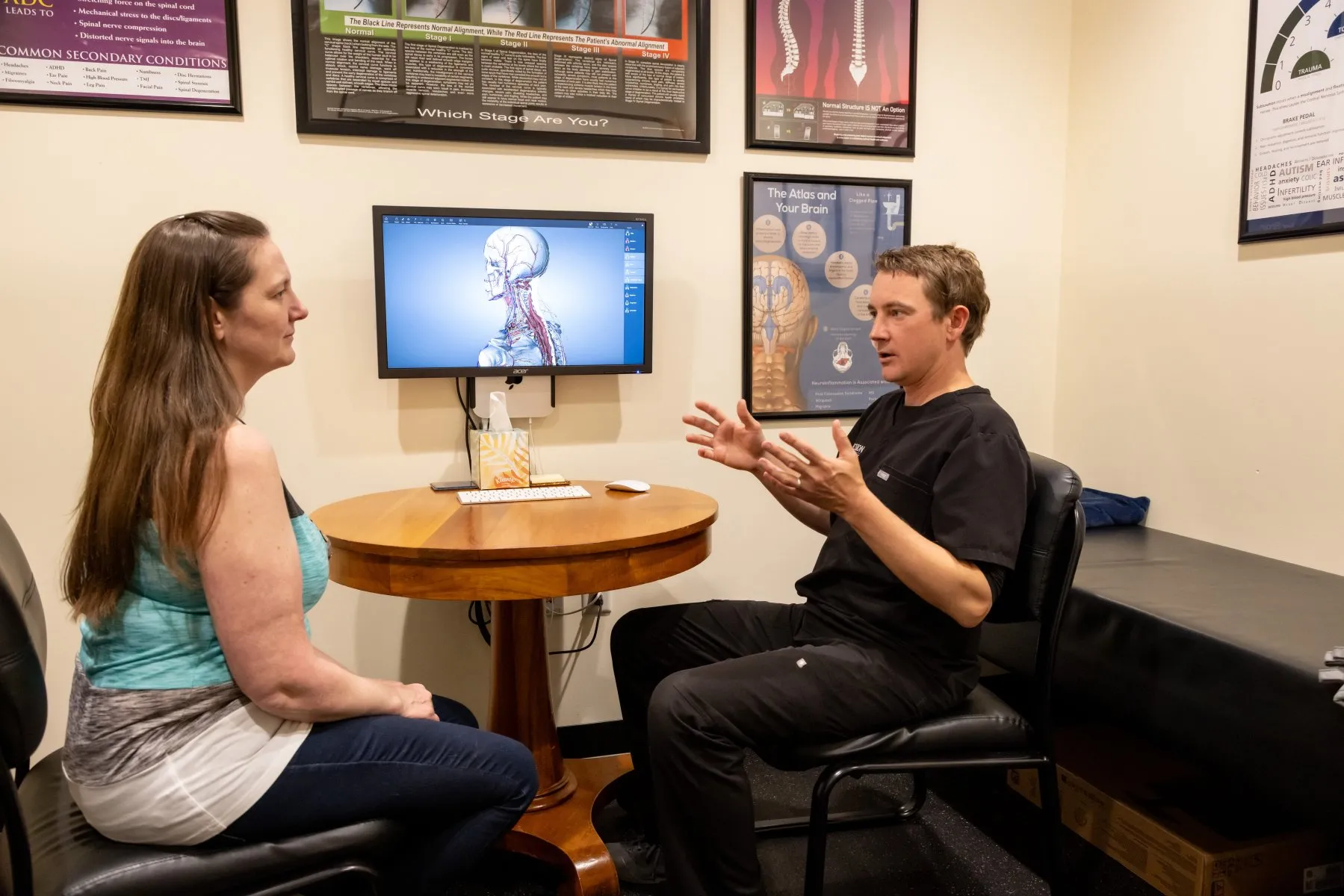 Dr. McCanse consulting with patient using 3D nervous system model to explain spinal alignment and its impact on health at Precision Chiropractic in Vermont