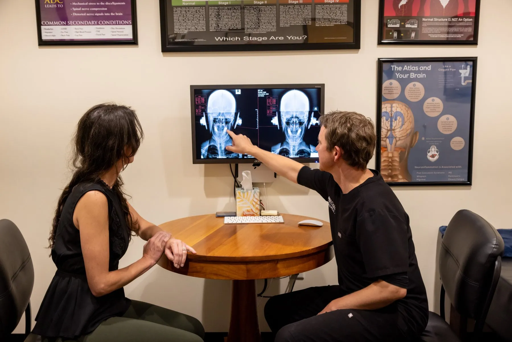 Dr. McCanse reviewing structural digital X-rays with a patient to assess spinal alignment at Precision Chiropractic in Vermont.